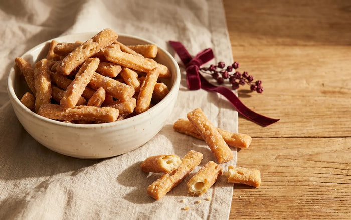 Discover hub card — What is Kurma: a bowl of golden sugar-glazed Kurma sticks on linen